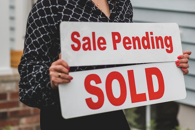 a%20person%20holding%20a%20sale%20pending%20and%20sold%20sign%20in%20front%20of%20a%20house a%20person%20holding%20a%20sale%20pending%20and%20sold%20sign%20in%20front%20of%20a%20house